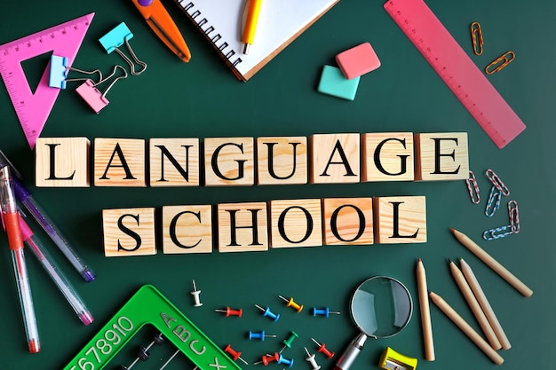 Colourful stationery and words SCHOOL HOLIDAYS on chalkboard