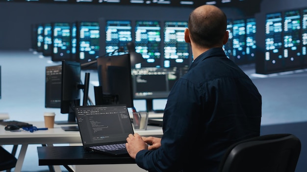 Computer scientist using laptop device to do programming in data center