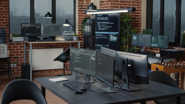 Computer screens running programming code in empty software it agency office and computers parsing data algorithms in background. Neural network servers cloud computing in data room.