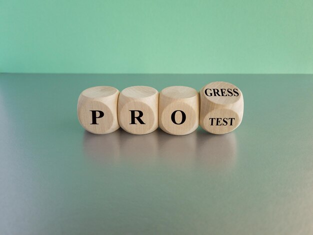 Concept word Progress Protest on beautiful wooden cubes Beautiful blue background