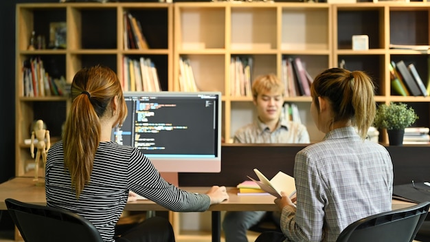 Creative software development team working with data debugging improvement binary algorithm code in corporate office