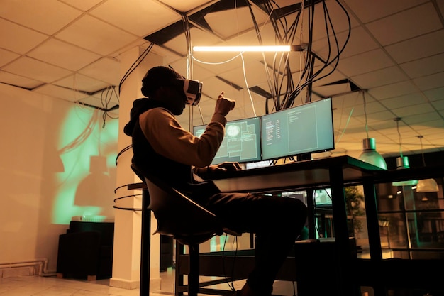 Criminal coding malware in virtual reality cracking database password in metaverse hacking online server stealing electronic information Cybercrime hacker in vr helmet at night time