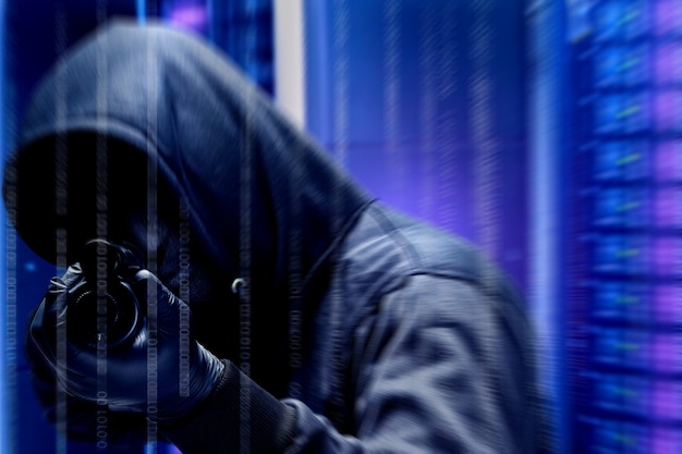 Criminal man in hidden mask pointing the shotgun with binary code background