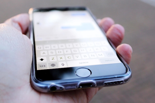 Cropped hand holding smart phone