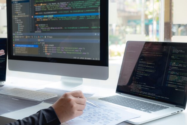 Cropped hand of computer programmers brainstorming in office