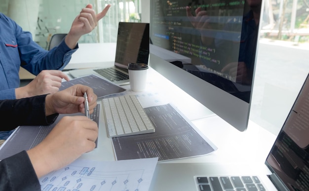 Cropped hand of computer programmers brainstorming in office
