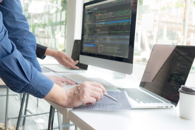 Cropped hand of computer programmers brainstorming in office