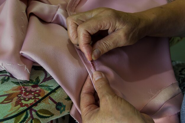 Cropped hand of woman sewing textile