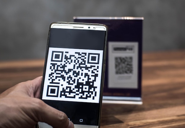 Cropped hand scanning qr code through smart phone