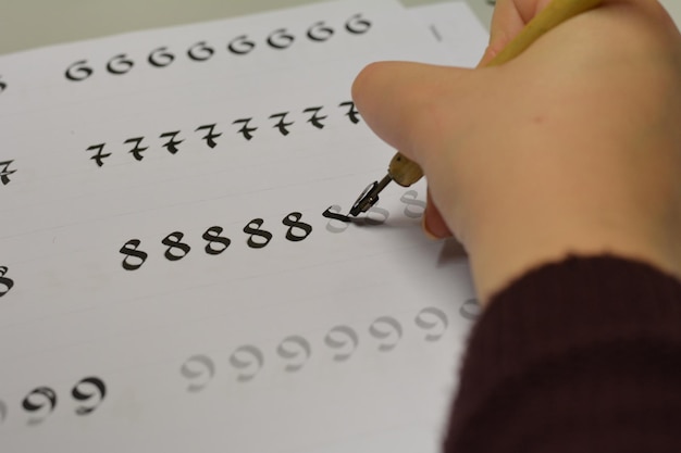 Cropped hand writing number on book