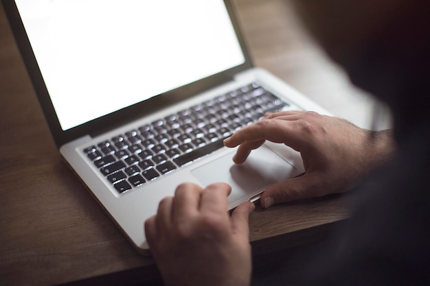 Cropped image man using laptop on table