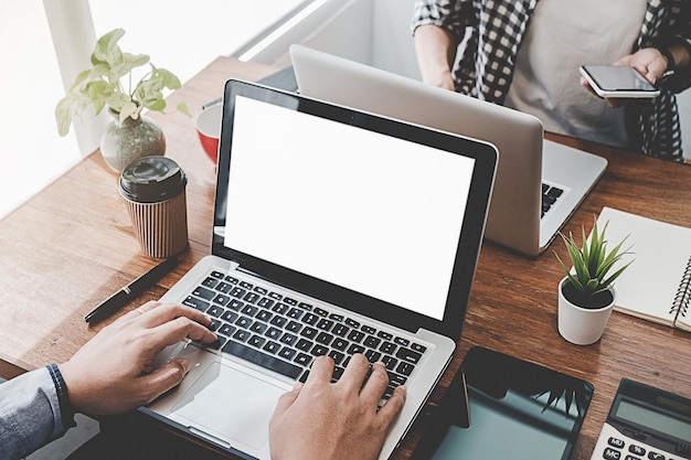 Cropped image of colleagues using technologies at desk