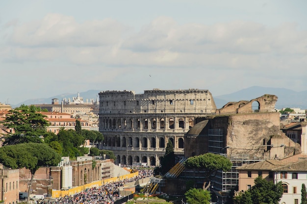 crowd in front of coliseum against cloudy sky