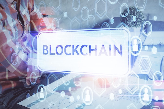 Crypto currency theme hologram with businessman working on computer on background Concept of blockchain Multi exposure