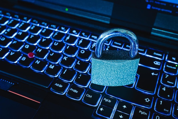 cyber security conceptiron padlocklock on laptop computer illuminated keyboardtonedselective focuscloseup