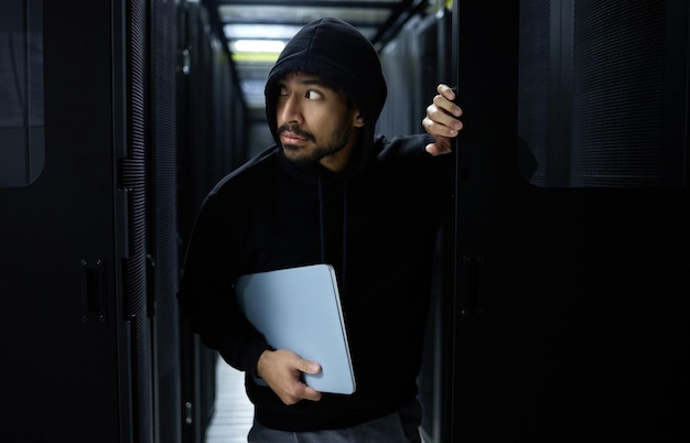 Cyber security crime and hacker in server room with laptop in data center stealing sensitive digital information Technology software and man hacking in database to update ransomware on website