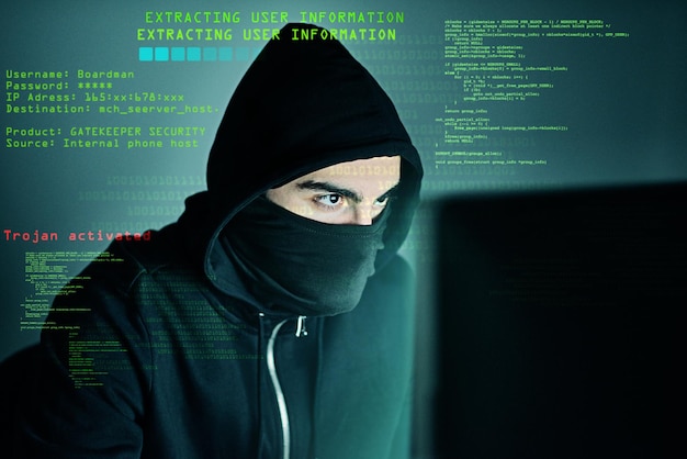 cybercrime hacker and computer virus with typing for code futuristic and cyber attack with overlay male criminal hoodie and ready for trojan horse corruption and programming for malware