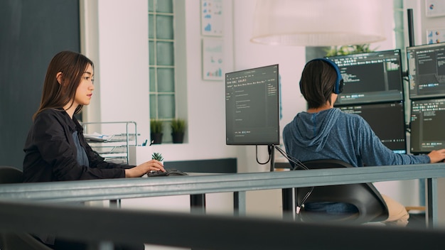 Databaseprogrammør skriver kildekode med kodningssprog i it-udviklingsrum. App udvikler arbejder på databaseprogrammering med html script, computing big data. Håndholdt skud.