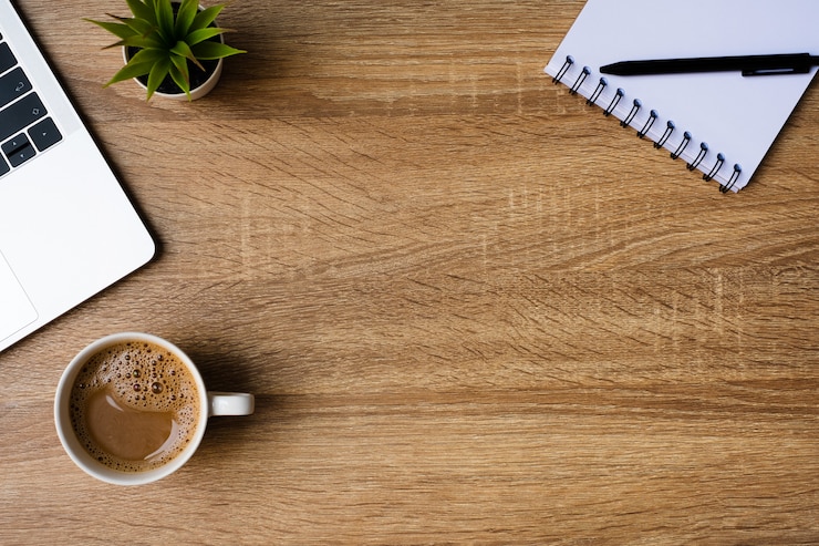 Foto desk office with laptop, blank notebook and coffee cup on wooden table