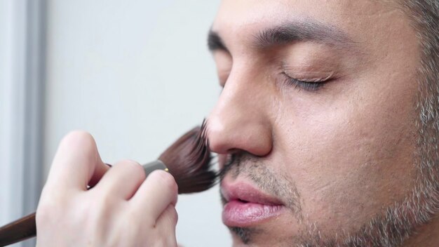 Detailed and CloseUp Makeup Application on a Male Model Showcasing His Features and Style