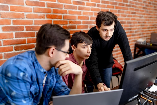 Developing programming and coding technologies. Website design. Three programmers working in a software develop company office