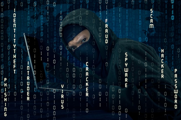 digital composite image of computer hacker with laptop
