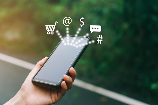 Digital composite image of cropped hand holding mobile phone by icons