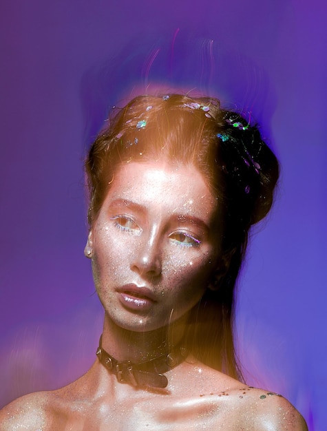 digital composite image of young woman with glitters against colored background