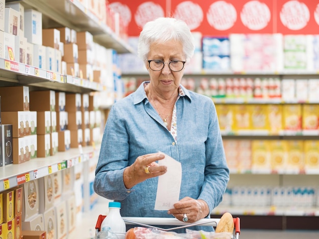 disappointed senior customer checking the grocery receipt