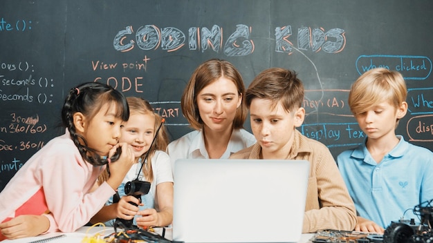 Diverse student writing engineering code while boy fixing board Erudition