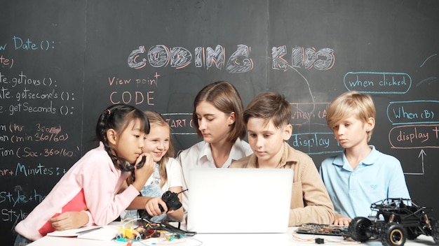 Diverse student writing engineering code while boy fixing board Erudition