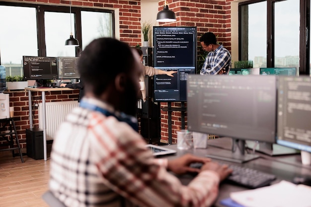 Diverse system engineers working on it project for the company network technology, utilizing their expertise in coding systems. Software developer programming big data in agency office.