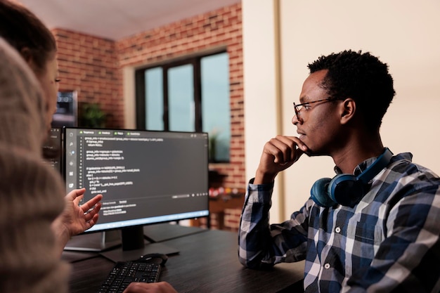 Diverse tech enginners developing machine learning algorithm in order to sustain system security stability. Software developer creating network using binary encryption in it agency office.