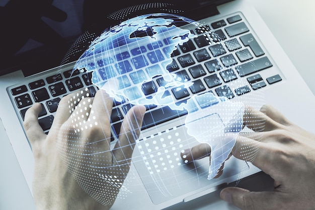 Dobbelt eksponering af digitalt Amerikakort og hænder der skriver på bærbar computer på baggrund af forskning og strategikoncept