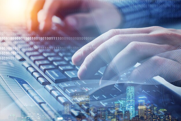 Double exposure business man working on laptop computer and the city. Software developer,