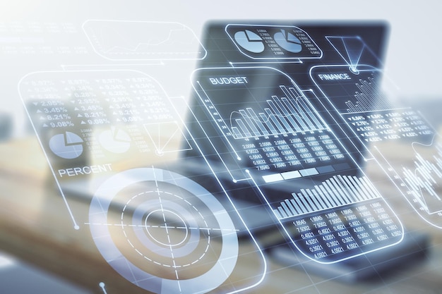 Double exposure of abstract creative statistics data hologram and modern desktop with laptop on background statistics and analytics concept