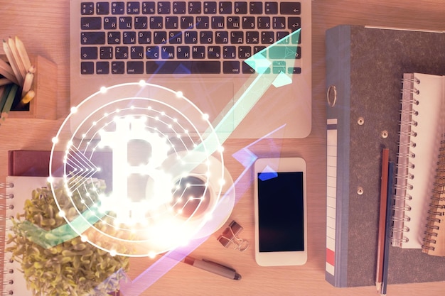 Double exposure of blockchain theme hologram over table with phone Top view Crypto technology concept