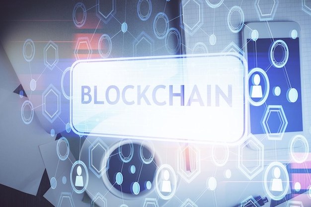 double exposure of blockchain theme hologram over table with phone top view crypto technology concept