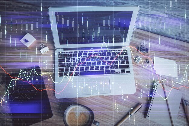 double exposure of financial chart drawing over table background with computer concept of research and analysis top view
