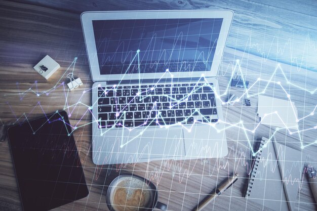 double exposure of financial chart drawing over table background with computer concept of research and analysis top view