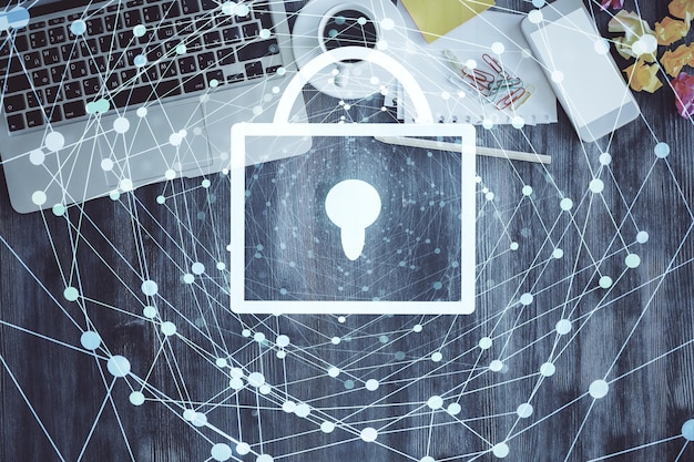 Double exposure of lock hologram drawing over study table background with computer Concept of data security Top view