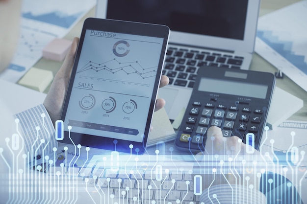 Double exposure of mans hand holding and using a digital device and data theme hologram drawing Technology concept