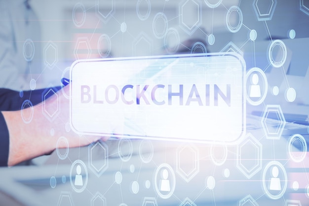 Double exposure of mans hands holding and using a phone and crypto currency blockchain theme drawing