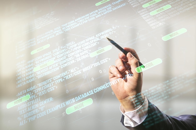 Double exposure of programmers hand with pen working with abstract creative programming illustration on blurred office background big data and blockchain concept