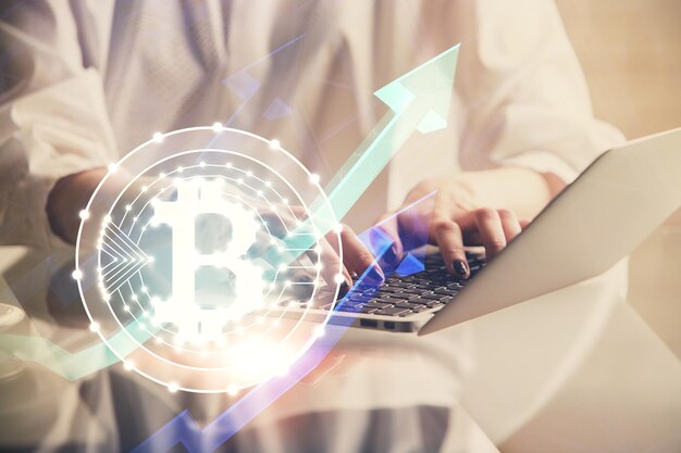 Double exposure of woman hands typing on computer and crypto market theme hologram drawing Blockchain concept