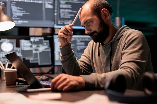 Eftertænksom programmør, der brainstormer ideer for at finde kildekode og udvikle html-script på terminalvinduet. Tænker på løsning til at oprette cloud computing server interface, kodningsprogram.