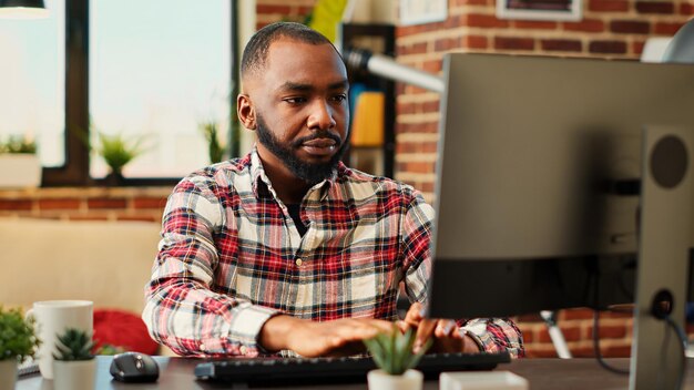 Employee concentrating on finishing up important job tasks, remotely working from stylish apartment personal office. Focued teleworker typing on computer keyboard, close up