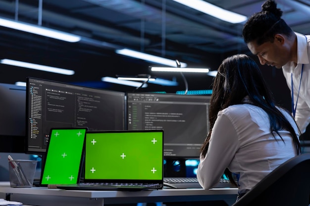 Employees in server room checking systems bottlenecks using chroma key devices