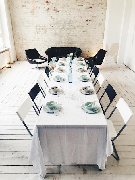 Empty bowls arranged on table by chairs in empty office