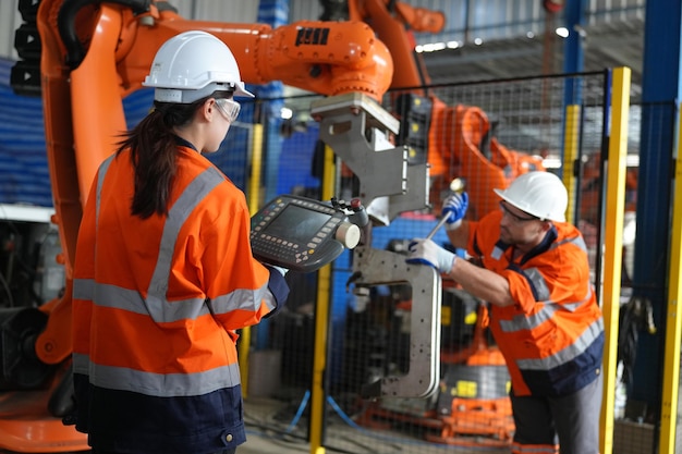 engineer check and control automation robot arms machine in intelligent factory industrial on real time monitoring system software robotics and digital manufacturing operation
